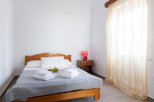 une chambre avec un lit avec des serviettes dessus dans l'établissement Mosxa House, à Artemonas