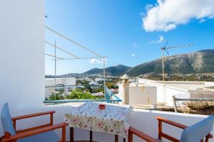 a table and chairs on a balcony with a view at Mosxa House in Artemonas