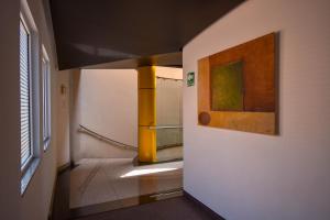 ein Flur mit einem Gemälde an der Wand neben einem Badezimmer in der Unterkunft Hotel Via La Villa in Mexiko-Stadt