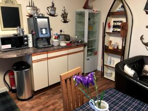 a kitchen with a counter top with a microwave at Hal O' The Wynd Guest House in Stornoway