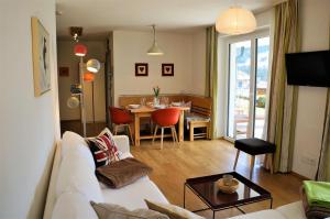 ein Wohnzimmer mit einem weißen Sofa und einem Tisch in der Unterkunft Appartement Germann in Neukirchen am Großvenediger
