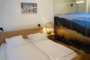 ノイキルヒェン・アム・グロースヴェンエーディガーにあるAppartement Germannのベッドルーム1室(ベッド1台付)が備わります。壁には絵画が飾られています。