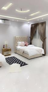 1 dormitorio con cama grande y cortina en مساكن الدار 1 en Abha