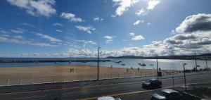 Llandrillo-yn-RhôsにあるHarbour Viewの海上の船と道路のある海岸