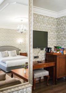 a bedroom with a bed and a desk with a mirror at Hotel Gritti Pera & Spa in Istanbul