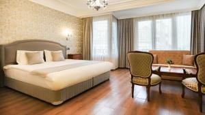 a hotel room with a bed and a desk and chairs at Hotel Gritti Pera & Spa in Istanbul