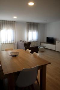 ein Wohnzimmer mit einem Holztisch und Stühlen in der Unterkunft Apartamento CATA Santiago de Compostela in Santiago de Compostela