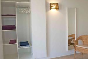 Pokój z białymi półkami, lampką i krzesłem w obiekcie Magallanes Apartment w Cala Ratjada