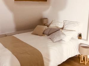 a bed with white sheets and pillows in a room at Maison entre terre et mer proche Etretat in Saint-Jouin-Bruneval