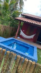 - une piscine dans une cour à côté d'une maison dans l'établissement Chalés Solar do Patacho, à Porto de Pedras