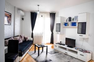 un soggiorno con divano e TV di Apartman Black Star a Novi Sad