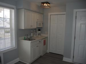 a kitchen with white cabinets and a sink and a door at 1408L home in Calabash