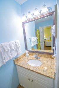 a bathroom with a sink, mirror, and towel rack at Grand Palms Resort in Myrtle Beach