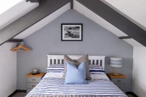 a bedroom with a bed with blue and white pillows at Central Penzance, Modern stylish home, Near Seafront with Gated parking in Penzance