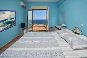 a bedroom with a large bed with a view of the ocean at Villa Blue Dream in Koutsounari