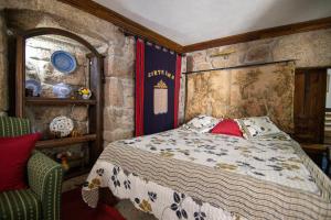 sypialnia z łóżkiem w kamiennej ścianie w obiekcie Casa da Vila w mieście Sortelha