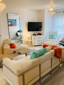 uma sala de estar com um sofá e uma televisão em Stunning Seafront House with garden and private parking em Eastbourne