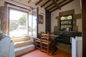 a kitchen with a table and a window and a counter at Casa da Vila in Sortelha