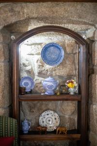 a shelf with blue and white dishes on it at Casa da Vila in Sortelha