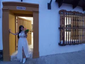 Una mujer con un vestido blanco parada al lado de un edificio en La 10B, en Cartagena de Indias