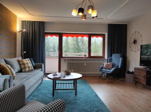 un soggiorno con un divano e un tavolo di Ferienwohnung Tannenballett im Schwarzwald a Baiersbronn