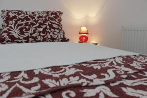 - un lit avec une couverture noire et blanche et une lampe dans l'établissement Sweet Home Vrnjačka Banja, à Vrnjačka Banja