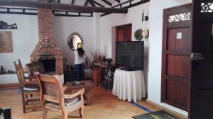 a woman standing in a living room with a fireplace at Casona Santo Domingo in Villa de Leyva