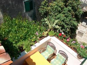 een balkon met stoelen en bloemen bij Apartments and rooms Jare - in old town in Trogir