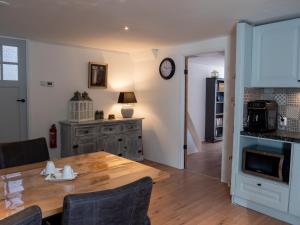 een keuken en eetkamer met een houten tafel bij Altynghe in Beilen