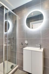 a bathroom with a shower and a sink and a mirror at Old town flat with sea view in Hastings
