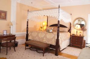1 dormitorio con cama con dosel y mesa en Silver Fountain Inn en Dover