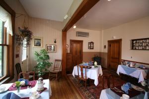 uma sala de jantar com duas mesas com toalhas de mesa brancas em The Governor's Inn em Ludlow