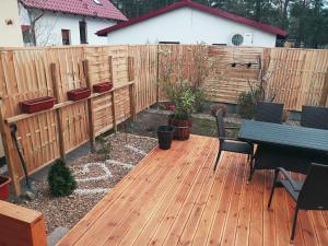 a wooden deck with a bench and a fence at Domek letniskowy Jolcia in Ujazdowo +6 photos
