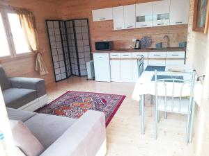 a living room with a table and a kitchen at Domek letniskowy Jolcia in Ujazdowo