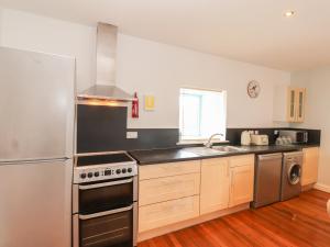 a kitchen with a sink and a stove top oven at Badger Cottage in Dalbeattie