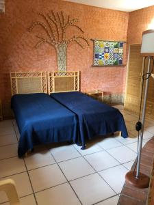 a bedroom with a blue bed with a tree on the wall at Oasi Bochini in Avola +11 photos