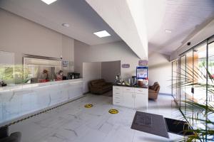 a large room with white tile floors and a large mirror at Hotel Sirari By Regina in Santa Cruz de la Sierra