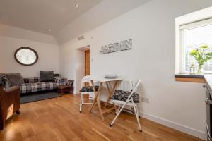 a living room with a table and chairs and a couch at Redlands Country Lodge Apartments with Hot Tubs in Ladybank