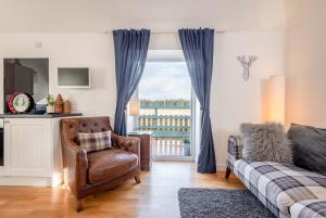 a bedroom with a bed and a chair and a window at Redlands Country Lodge Apartments with Hot Tubs in Ladybank