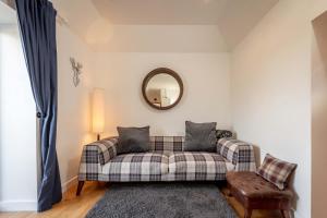 a living room with a couch and a mirror at Redlands Country Lodge Apartments with Hot Tubs in Ladybank