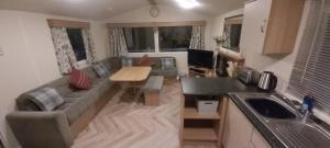 a living room with a couch and a table at The Hackle Hot Tub Retreat in Felton