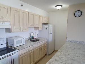 a kitchen with white appliances and a white refrigerator at PonoAloha in Honolulu