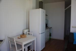 uma cozinha com uma mesa e um frigorífico branco em Galua- SweethomeRooms Cabo de Palos em Cabo de Palos