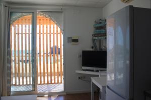uma sala de estar com uma porta de vidro deslizante e uma televisão em Galua- SweethomeRooms Cabo de Palos em Cabo de Palos