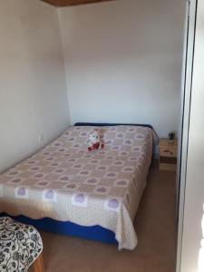 una camera da letto con un letto con un orsacchiotto sopra di Apartments Mateo - by the beach; a Gdinj