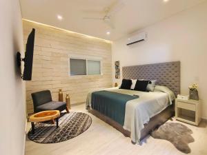a bedroom with a large bed and a chair at 1st Luxury Warehouse in Cancún