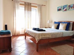 アルマカオ・デ・ペラにあるCharming Beach Apartmentのベッドルーム(青い枕の大型ベッド1台付)