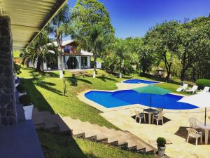 uma vista superior de uma casa com uma piscina e um guarda-sol em DR Hotel Rio Branco do Sul em Votuverava