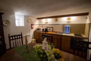 a kitchen with a table and a counter top at Casa do Campanário in Sortelha