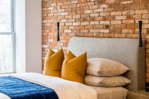 ケベック・シティーにあるINITIAL - SUITE LEMIEUX - PARKING - Centre-Ville de Québecのレンガの壁とベッド(枕付)が備わるベッドルーム1室が備わります。